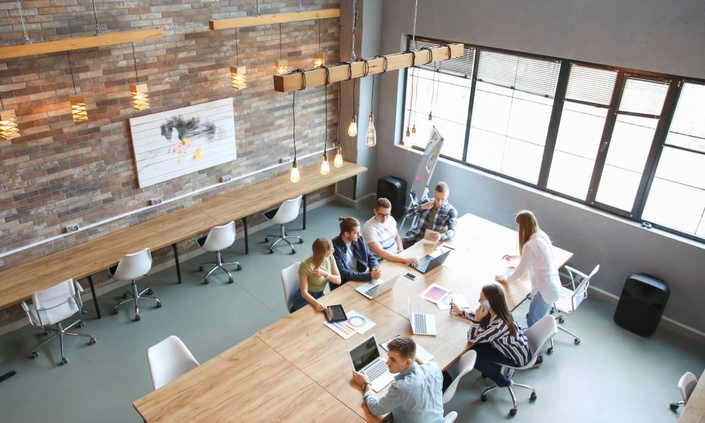 Group of employees working at a conference desk in a modern office