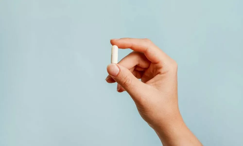 Woman holding a pharmaceutical pill