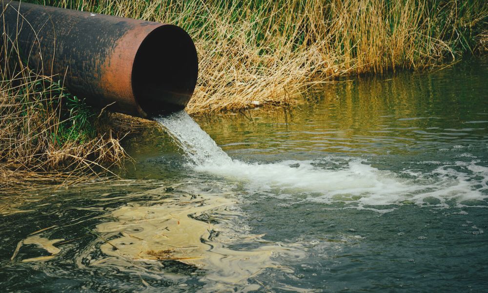 harmful waste water running into river from a pipe