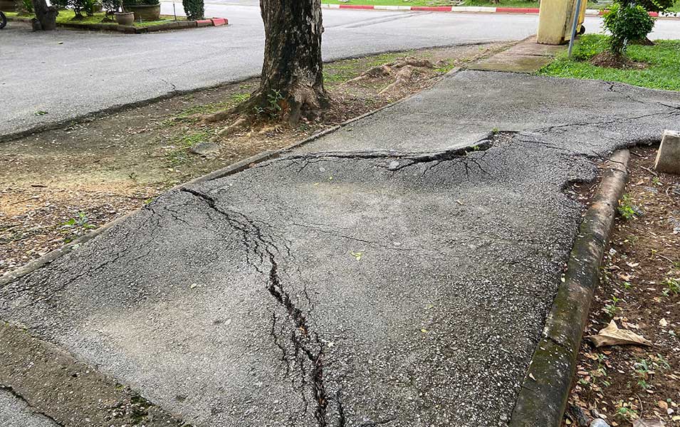 sidewalk with big cracks in the concrete that may cause a slip and fall accident